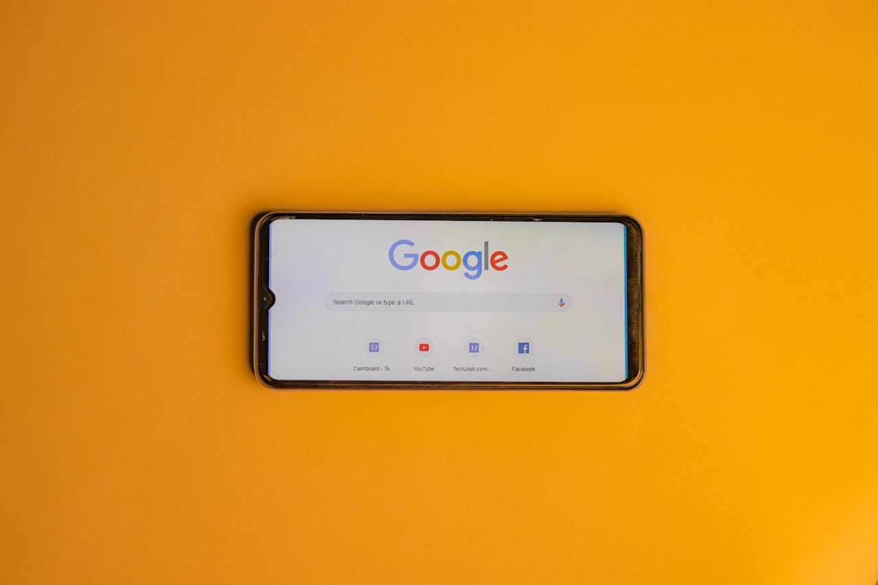 services-03 Smartphone displaying Google search page on a vibrant yellow background.