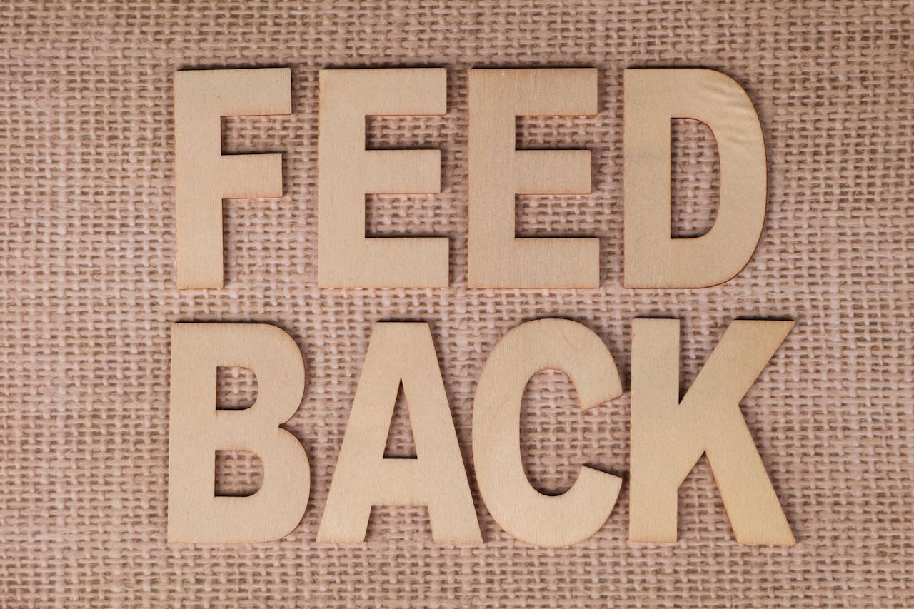 Wooden letters spelling 'FEEDBACK' on a burlap background, emphasizing communication.