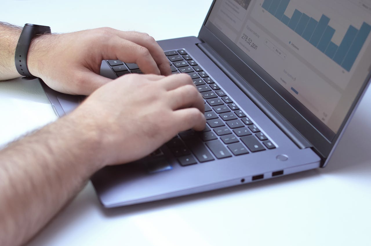 services-01 From above side view of crop unrecognizable male marketer working on netbook while using analytical software in office