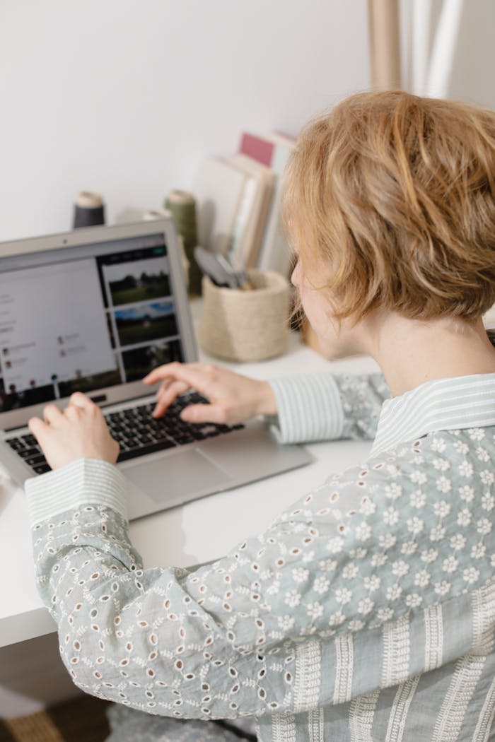 gallery-2 Woman using laptop at home desk for remote work, embodying digital nomad lifestyle.